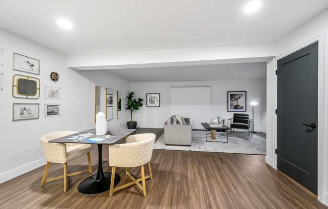 a dining area with a table and chairs and a couch in the background