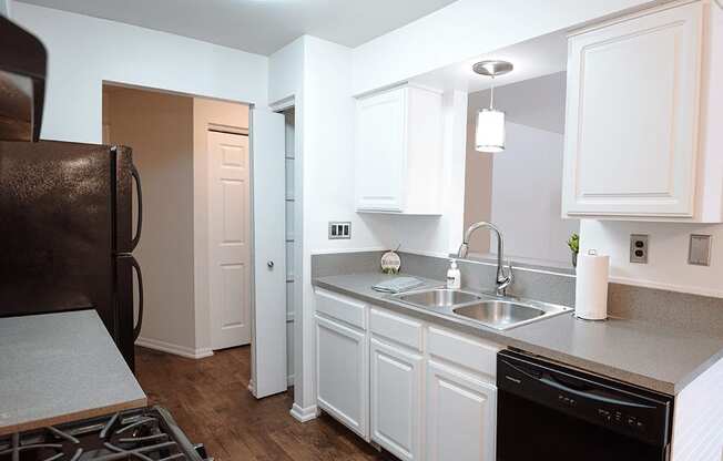 a kitchen with white cabinets and a sink and a refrigerator