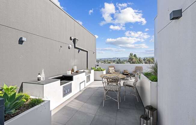 A patio with a table and chairs overlooks a cityscape.