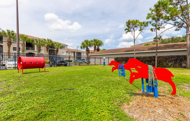 a playground with a red dog and a blue dog on a grassy field at Heritage Bay, Jensen Beach, 34957