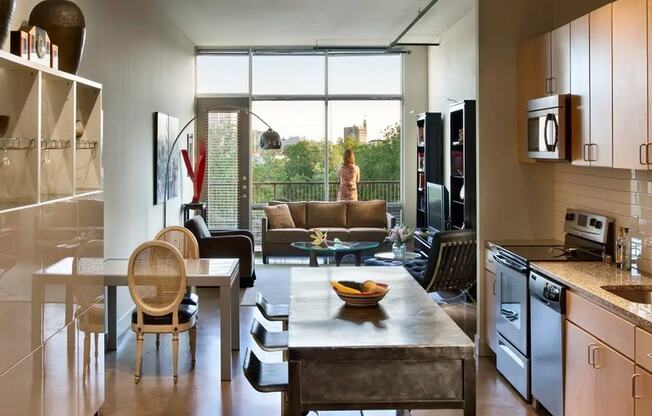 a kitchen and living room with a large window and a table