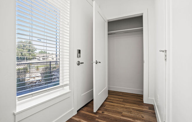 a bedroom with a window and a door to a closet  at Aero Luxury Townhomes in Layton, Utah
