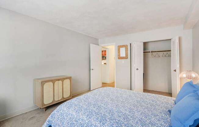 A bedroom with a bed, a nightstand, and a wardrobe.