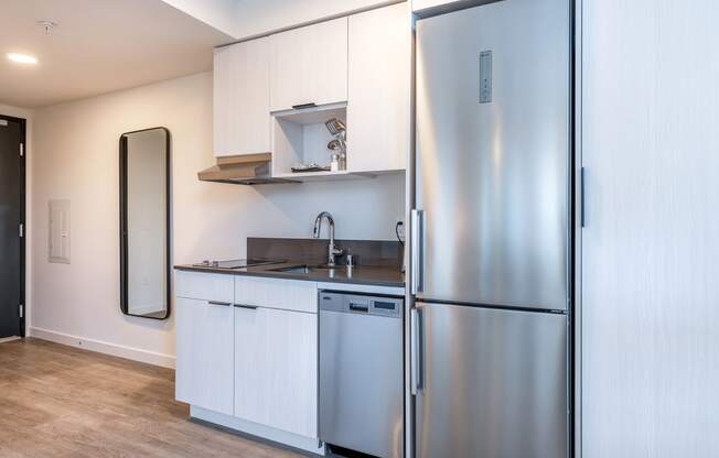 a small kitchen with white cabinets and stainless steel appliances at Marina Square, Bremerton, Washington 98337