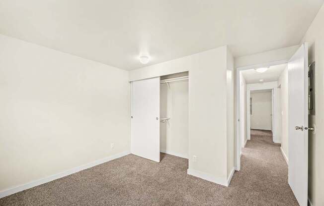 A long hallway with carpeted floors and white walls.