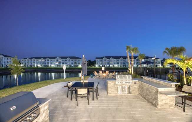 a patio with a table and chairs next to a body of water