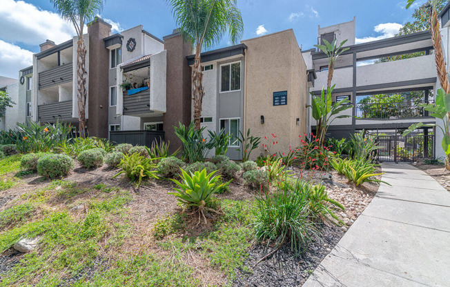 a house with a sidewalk and plants in front of it at City View Apartments at Warner Center, Woodland Hills