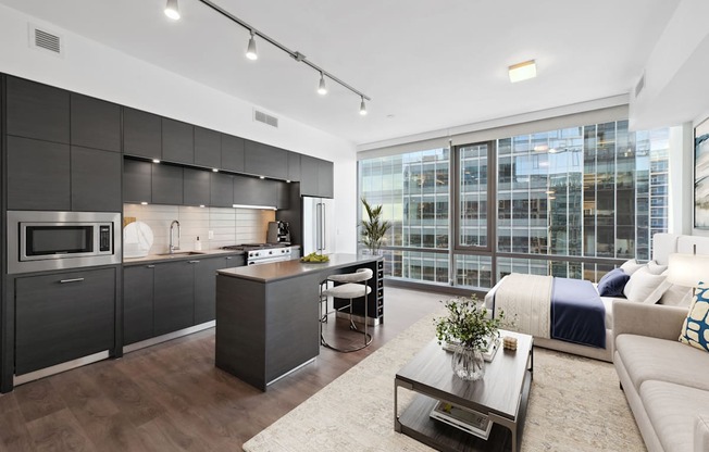 a living room with a kitchen and a bed