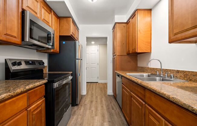 a kitchen with wooden cabinets and black appliances