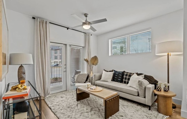 a living room with a couch and a ceiling fan