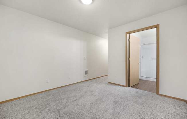 a bedroom with white walls and a carpeted floor