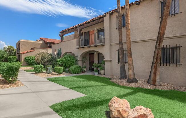 a close up of a stone building with grass in front of a house