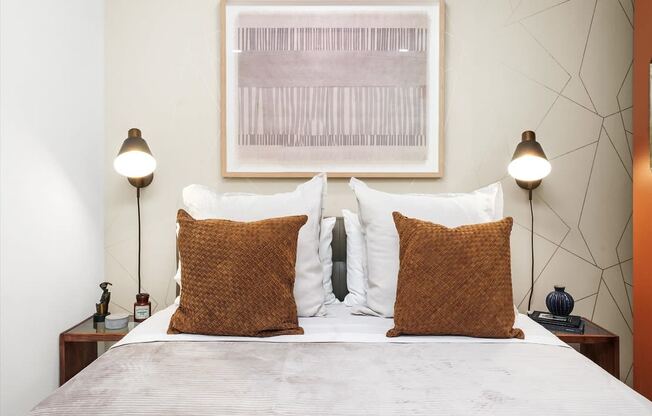 a bedroom with a bed with two pillows and two lamps