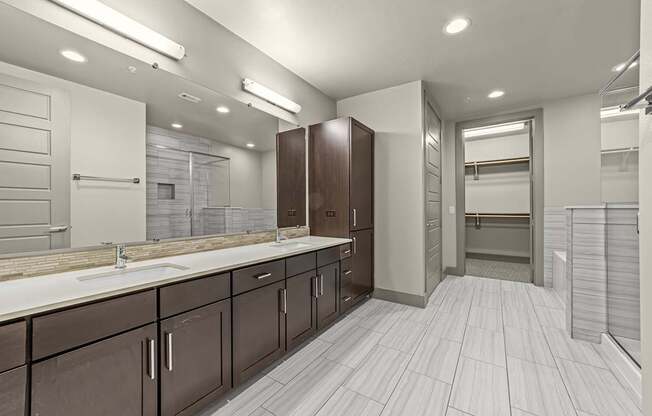 A bathroom with brown cabinets and white countertops.