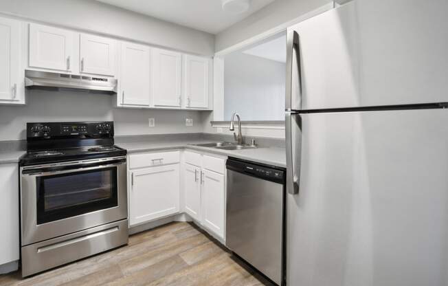 a kitchen with stainless steel appliances and white cabinets