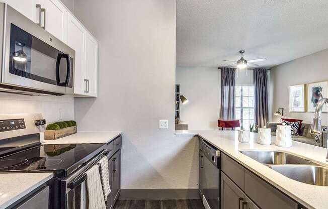 A modern kitchen with a stainless steel oven and microwave.