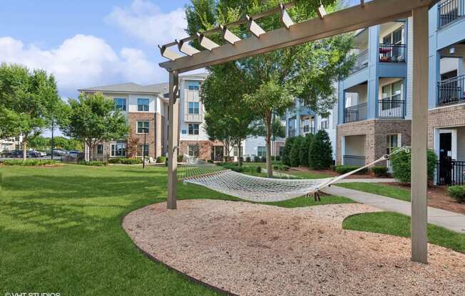 a hammock is hanging on a pole in front of an apartment building