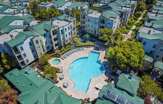 An aerial view of apartment buildings surrounding a swimming pool.