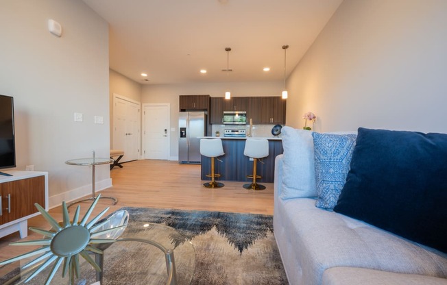 a living room with a couch and a kitchen