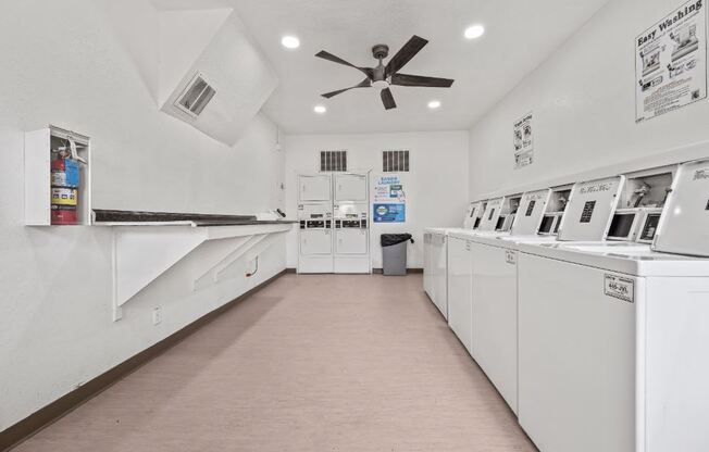 a laundry room with white appliances and a ceiling fan