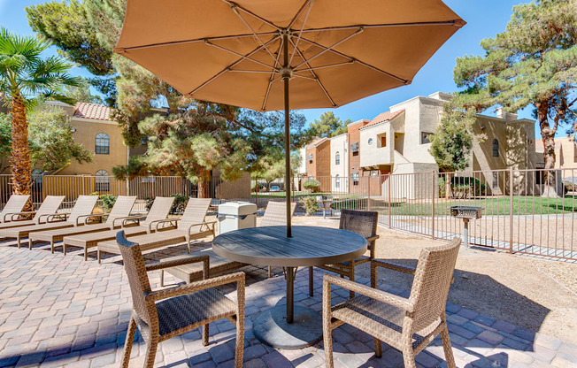 a patio with a table and chairs and an umbrella at Pacific Harbors Sunrise Apartments, Nevada, 89142