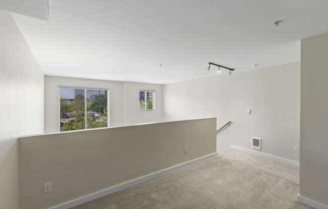 Second Floor Loft Bedroom with Large Windows and Plush Carpet Flooring at Sir Gallahad Apartment Homes, WA 98004