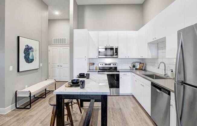 a modern kitchen with stainless steel appliances and white cabinets