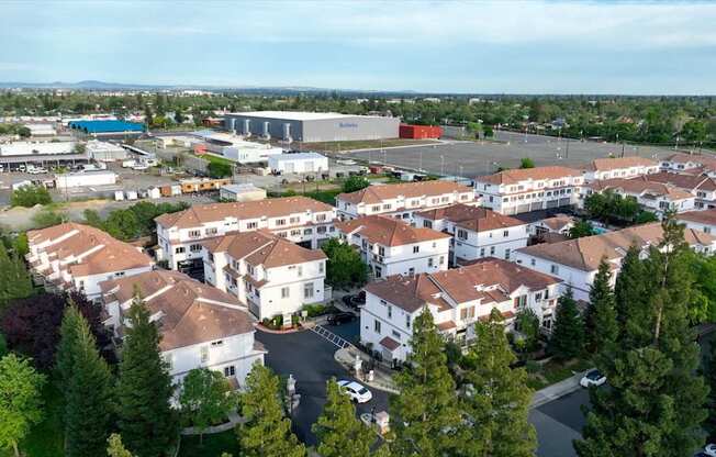 A large white building complex surrounded by trees.