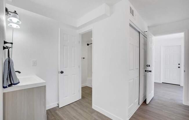 A white bathroom with a sink and a light on.