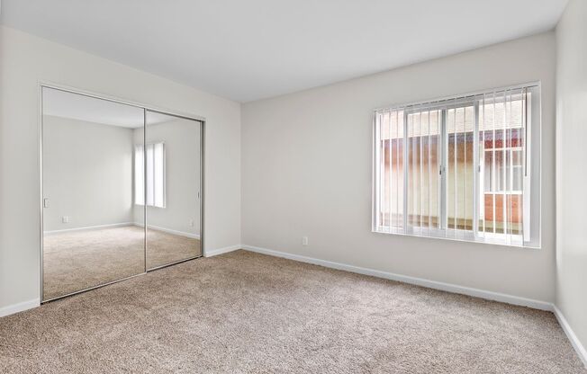 a bedroom with a large window and a mirror