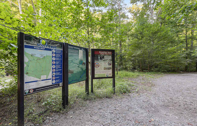 A signpost in a wooded area with a map and information about the area.