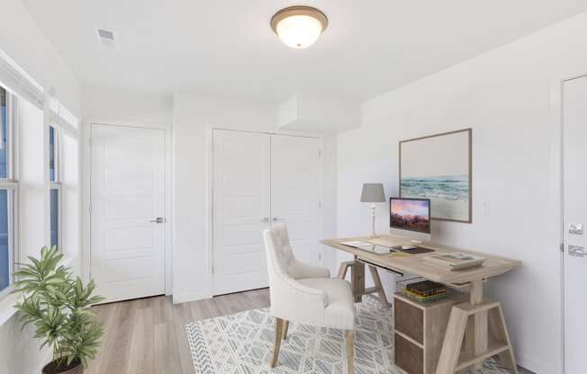 a home office with white walls and white doors and a desk with a white chair