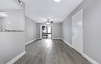 an empty living room with white walls and a ceiling fan