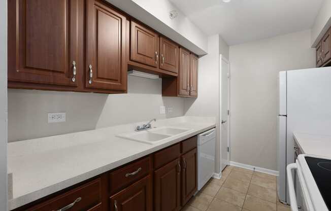 a kitchen with wooden cabinets and a sink and a refrigerator