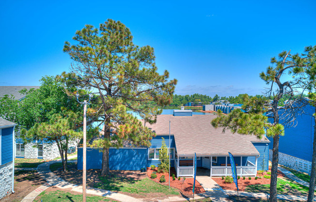 an aerial view of a house with trees and a blue fence