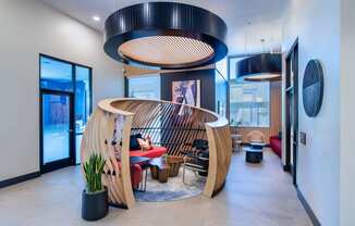 a living room with a wooden spiral staircase and a table and chairs