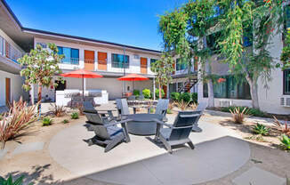 a patio with a table and chairs in front of a building