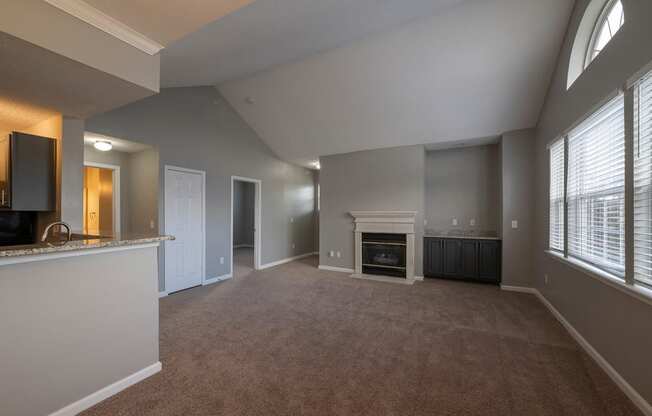 a living room with a fireplace and a kitchen