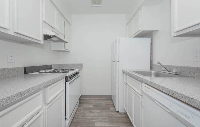 A white kitchen with a stove, oven, and refrigerator.