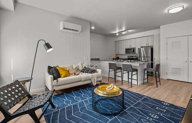 a living room and kitchen with a couch and a table