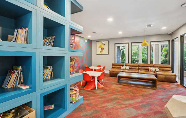 A living room with a blue bookshelf and a red carpet.