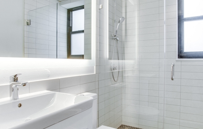 Luxury bathroom with chrome fixtures, natural light and rain shower