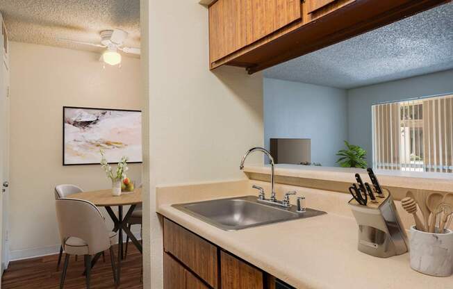 A kitchen with a table and chairs and a sink.