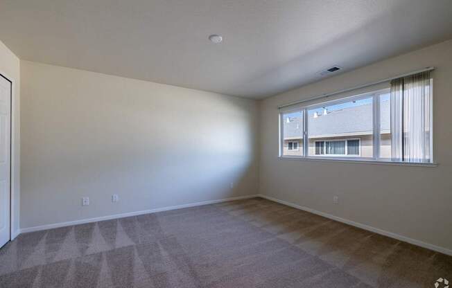 an empty living room with a large window