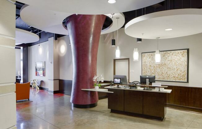 a lobby with a reception desk and a large red pillar