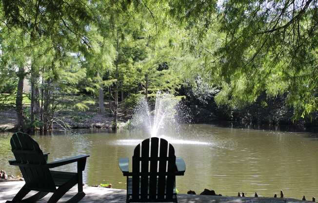 a fountain in a pond with two adirondack chairs at Stillwater at Grandview Cove