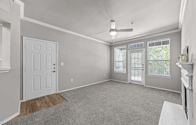 A room with a door, a window, and a ceiling fan.