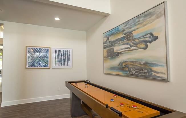 a games room with a pool table and artwork