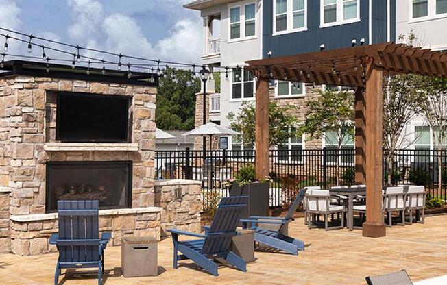 a patio with a fireplace and tables and chairs at Promenade at Newnan Crossing, Georgia, 30265