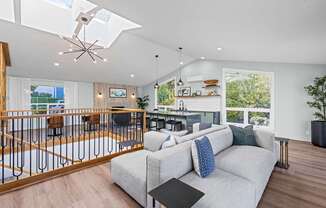 A modern living room with a grey couch and a black coffee table.